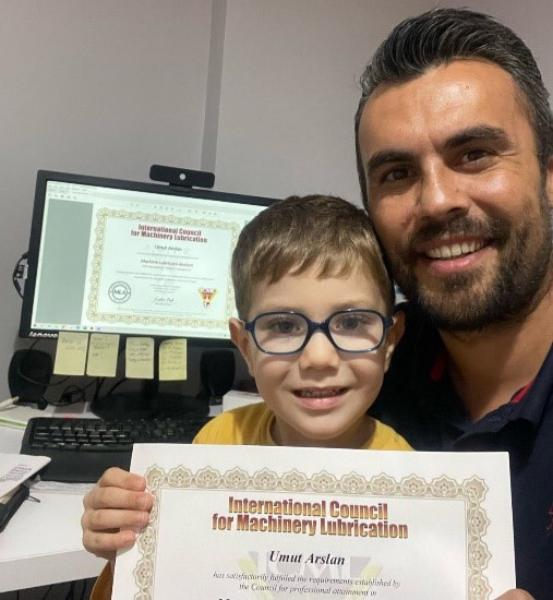 Umut and son proudly display his ICML certificates.