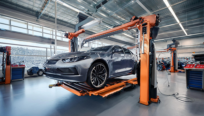 A sports car getting prepped for maintenance in a clean shop.